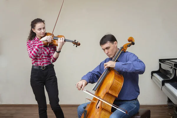 Musicians of the symphony orchestra. Young violinist and cellist in concert costumes. — Stock Photo, Image