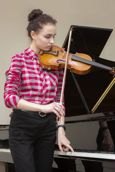 女孩拉小提琴。 一个人在家学习音乐的年轻女人. — 图库照片