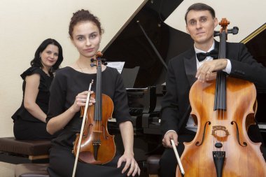 Aile müziği üçlüsü. Genç bir kemancı ve çellocu onlara eşlik eder..