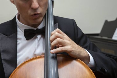 Senfoni orkestrasının müzisyenleri. Konser kostümlü çellocu.