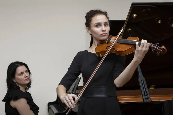 심포니 오케스트라의 음악가들. 음악회 의상을 입은 젊은 바이올린 연주자와 피아니스트. — 스톡 사진