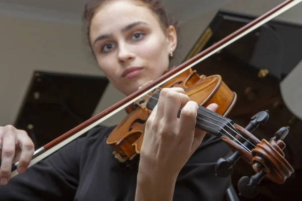 La mano di una violinista donna sulla tastiera di un violino prende un accordo durante l'esecuzione musicale . — Foto Stock