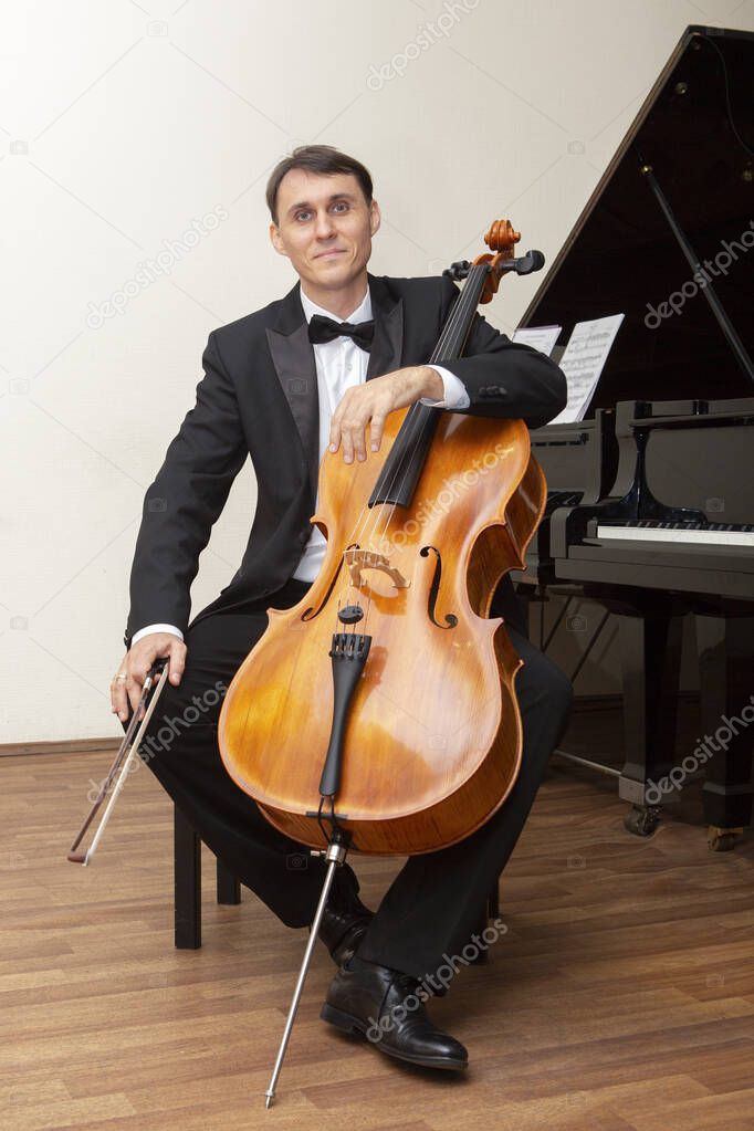 Musicians of the symphony orchestra. Cellist in concert costume.
