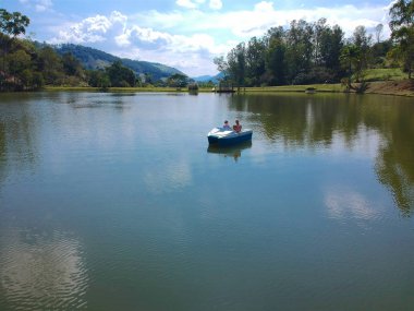 Brezilya'da gölde pedallı bot üzerinde havadan görünümü güzel bir çift. Çift romantik sahne dron görünümünü pedal teknede arka, tatil eğlenceli bir deniz bisikleti üzerinde dağ ve orman.