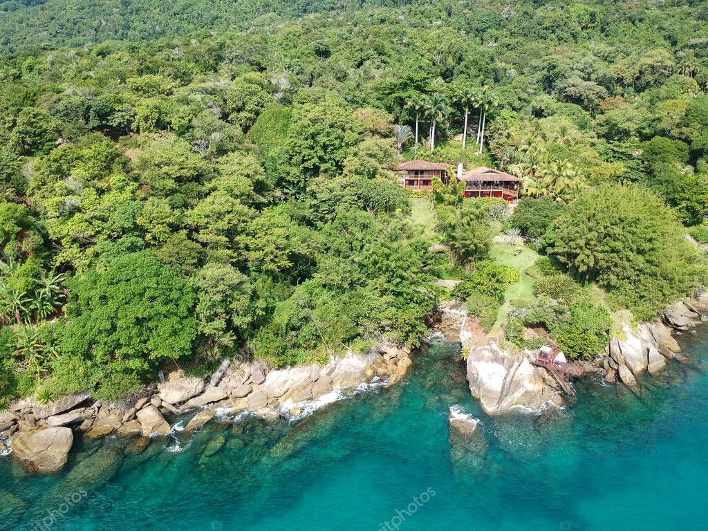 Vista aérea de casa de lujo en bosque tropical rodeado de árboles y al