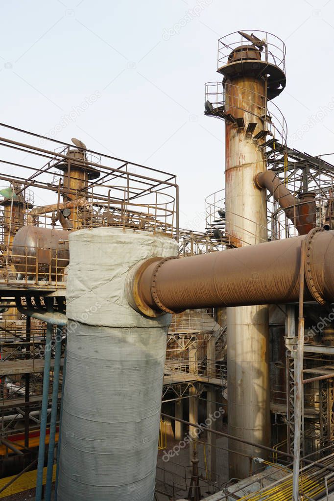 Old Factory metal structures. Industrial plant with old, rusty pipes and cooling tower for cooling water supply. Beijing, China.