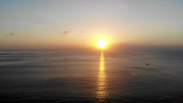 空中的日落在海上与一些小船 巴厘岛 印度尼西亚 太阳落山在海洋上 宁静的田园诗般的场景 金色的日落在海上与反思 — 图库视频影像