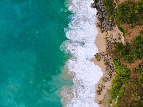 在沙质海岸线上有岩石悬崖的蓝色大海鸟图 美丽的绿松石海水与海浪冲浪在夏季在巴厘岛 美丽的印度洋景观 度假胜地 — 图库照片