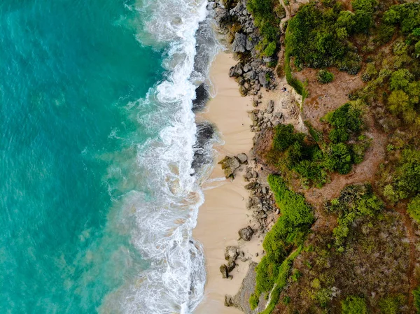 在沙质海岸线上有岩石悬崖的蓝色大海鸟图 美丽的绿松石海水与海浪冲浪在夏季在巴厘岛 美丽的印度洋景观 度假胜地 — 图库照片
