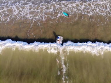 Havadan görünümü sörfçü Bali, Endonezya karanlık, kahverengi su dalgalarda bekliyor. sörfçü dalgalar, sörfçü dalgaları bekleyen onların yönetim kurulu 