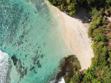 Kumlu sahil şeridi üzerinde hava görünümünü bir şaşırtıcı doğa manzara ile rock cliff. Güzel deniz suyu ile dalgalar Bali yaz sezonu sörf için. Güzellik Hint Okyanusu manzara, tatil beldesi
