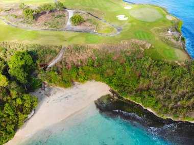 Bali adasında uçurum, okyanus ve plaj yanında lüks golf sahası havadan görünümü, Endonezya. Golf sahasında patikanın havadan görünümü.