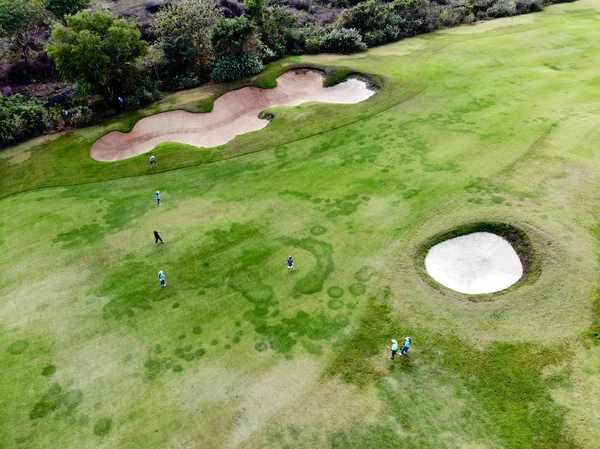 Aerial view of pound on golf course with player, footpath on golf course, player enjoying the game under sun, golf field ariel view, Bali, Indonesia