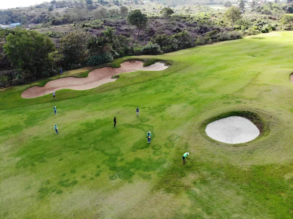Aerial view of pound on golf course with player, footpath on golf course, player enjoying the game under sun, golf field ariel view, Bali, Indonesia