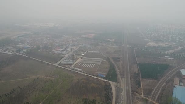 Petite zone rurale pauvre à l'extérieur de Pékin, entourée de terres agricoles, de petites usines et de voies ferrées. Journée gris pollution extrême. Chine .