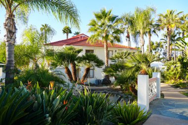 Tipik Güney Kaliforniya, İspanyolca güzel bahçe ağaçları ve palmiye ağaçları ile çevrili konut tarzı. San Diego, Kaliforniya, ABD