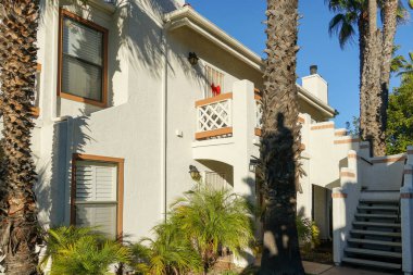 Tipik Güney Kaliforniya, İspanyolca güzel bahçe ağaçları ve palmiye ağaçları ile çevrili konut tarzı. San Diego, Kaliforniya, ABD