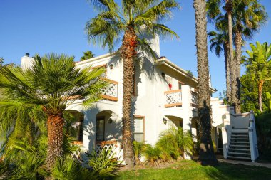 Tipik Güney Kaliforniya, İspanyolca güzel bahçe ağaçları ve palmiye ağaçları ile çevrili konut tarzı. San Diego, Kaliforniya, ABD
