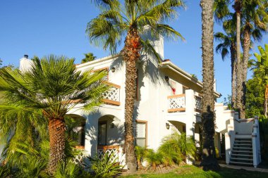 Tipik Güney Kaliforniya, İspanyolca güzel bahçe ağaçları ve palmiye ağaçları ile çevrili konut tarzı. San Diego, Kaliforniya, ABD