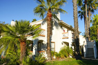 Tipik Güney Kaliforniya, İspanyolca güzel bahçe ağaçları ve palmiye ağaçları ile çevrili konut tarzı. San Diego, Kaliforniya, ABD