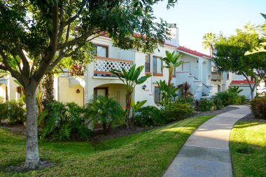 Tipik Güney Kaliforniya, İspanyolca güzel bahçe ağaçları ve palmiye ağaçları ile çevrili konut tarzı. San Diego, Kaliforniya, ABD