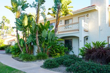 Tipik Güney Kaliforniya, İspanyolca güzel bahçe ağaçları ve palmiye ağaçları ile çevrili konut tarzı. San Diego, Kaliforniya, ABD