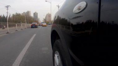 Görünüm penceresi ve sürücü arabanın içindeki yansıması ile aracın yan görünümden sürüş. Pekin kentinin, Çin yolda kirli gün boyunca araba yan kamera.