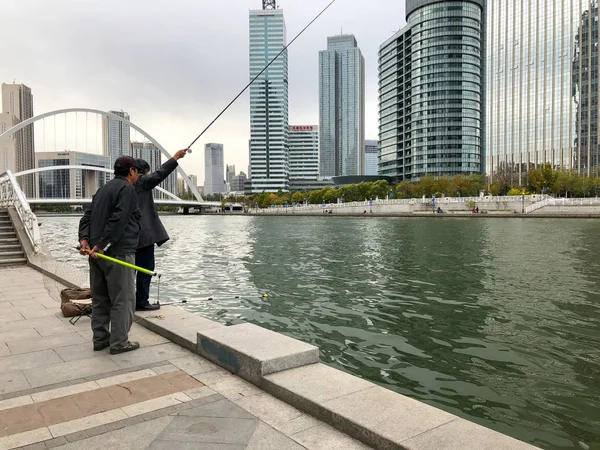 中国天津市内賓川の堤防で漁師 ウォーター フロントに座っていると 魚を捕まえるを待つ漁師 趣味の概念 — ストック写真