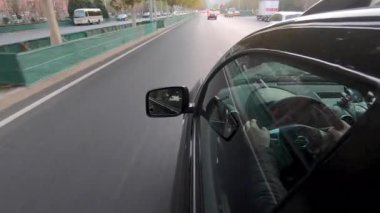 Görünüm penceresi ve sürücü arabanın içindeki yansıması ile aracın yan görünümden sürüş. Pekin kentinin, Çin yolda kirli gün boyunca araba yan kamera.