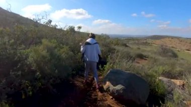 San Diego, Kaliforniya, ABD kara dağ tırmanma genç kadın sportif uzun yürüyüşe çıkan kimse. Kadın uzun yürüyüşe çıkan kimse mavi güneşli gün boyunca dağın yukarı ve aşağı gidiyor. sportif ve sağlıklı yaşam konsepti.