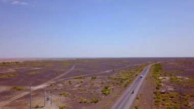 Günbatımı sırasında Sincan Uygur Özerk Bölgesi, Çin içinde çöl sonraki Ailik veya aylık gölün ortasındaki boş bir yolda araba havadan görünümü.