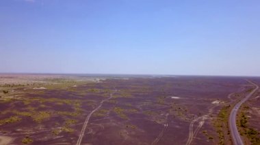 Günbatımı sırasında Sincan Uygur Özerk Bölgesi, Çin içinde çöl sonraki Ailik veya aylık gölün ortasındaki boş bir yolda araba havadan görünümü.