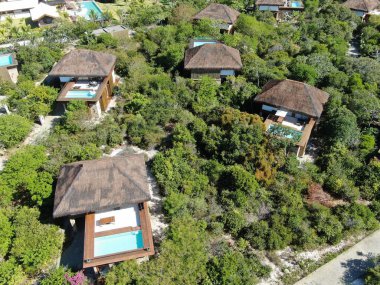 Havadan görünümü tropikal orman içinde yüzme havuzlu lüks Villa. Palmiye ağaçlarının yanında sahil tropikal bahçe arasında yüzme havuzlu özel tropikal villa. Praia de Forte, Bahia, Brezilya