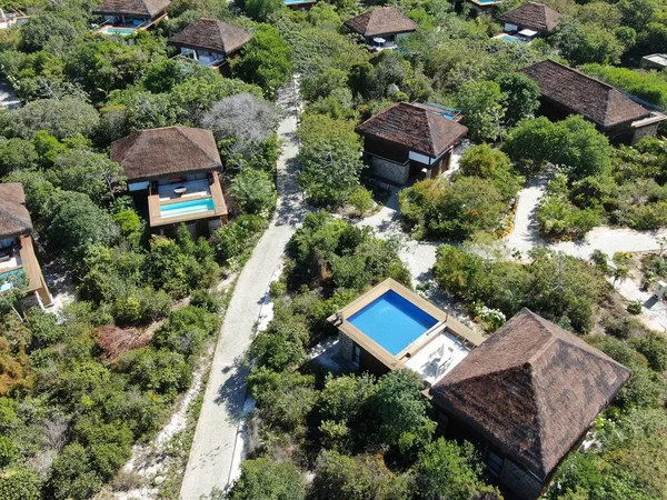 Aerial view of luxury villa with swimming pool in tropical forest. Private tropical villa with swimming pool among tropical garden with palm trees next to the coast. Praia de Forte, Bahia, Brazil