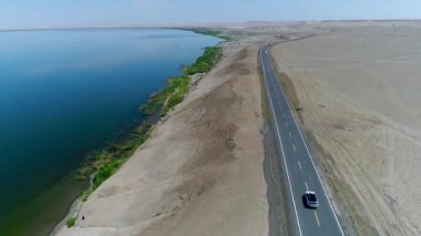 Sincan Uygur Özerk Bölgesi, Çin içinde çöl sonraki Ailik veya aylık gölün ortasındaki boş bir yolda araba araba havadan görünümü. 