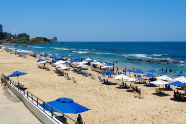 İnsanlar güneş zevk, plaj ve mavi Porto da Barra Beach adlı sonraki Brezilya Bahia Salvador Barra deniz feneri su. 