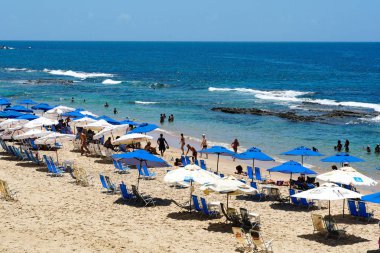İnsanlar güneş zevk, plaj ve mavi Porto da Barra Beach adlı sonraki Brezilya Bahia Salvador Barra deniz feneri su. 