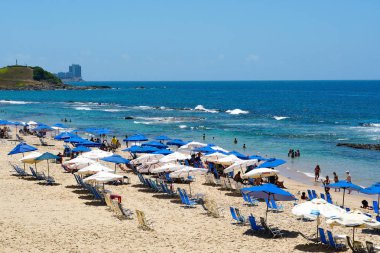 İnsanlar güneş zevk, plaj ve mavi Porto da Barra Beach adlı sonraki Brezilya Bahia Salvador Barra deniz feneri su. 