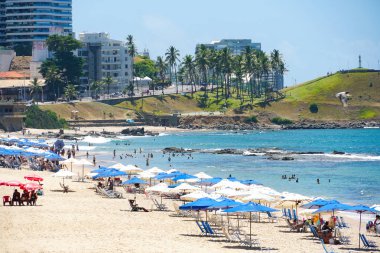 İnsanlar güneş zevk, plaj ve mavi Porto da Barra Beach adlı sonraki Brezilya Bahia Salvador Barra deniz feneri su. 