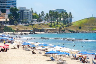 İnsanlar güneş zevk, plaj ve mavi Porto da Barra Beach adlı sonraki Brezilya Bahia Salvador Barra deniz feneri su. 