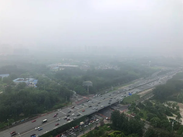 Top view highway with severe air pollution, fog and haze in Beijing city, China. Air pollution is a serious problem in Beijing, China