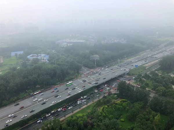 Top view highway with severe air pollution, fog and haze in Beijing city, China. Air pollution is a serious problem in Beijing, China