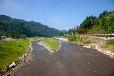Sichuan, Çin dağ nehre bakan güzel arka plan. Kayalar ve küçük şelale sulu yüzey, büyük nehir dağda yansıması. 