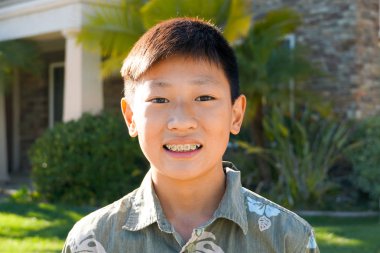 Genç çocuk diş diş telleri ile Asya çocuk portresi. Gülümseyen ve onun ortodontik diş telleri dişlerinde gösterilen genç genç çocuk.