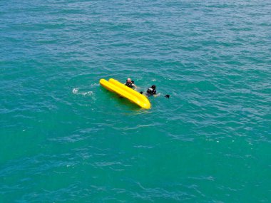 Havadan görünümü görünüm açık mavi turkuaz su okyanusun üzerinde onların kayık ile alabora güçlü aktif erkek. Aktif bir tatil. Praia Forte, Brezilya. 
