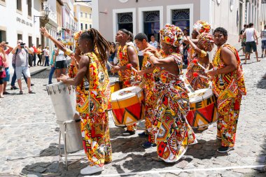 Dansçının küçük geçit töreni geleneksel kostümler ve aletleri revelers ile sokakta Salvadore, Bahia, Brezilya karnaval kutluyor