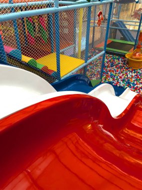 Modern çocuk oyun alanı kapalı. Bir slayt güzel çocuklar oyun alanında içinde. Plastik kuru havuz oynamak için renkli topları ile. Renkli plastik sakız topları arka planda çocuk oyun odası