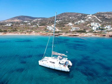 Catamaran sailing in  blue, turquoise water in Greece, beautiful catamaran next to the coast during summer holiday clipart