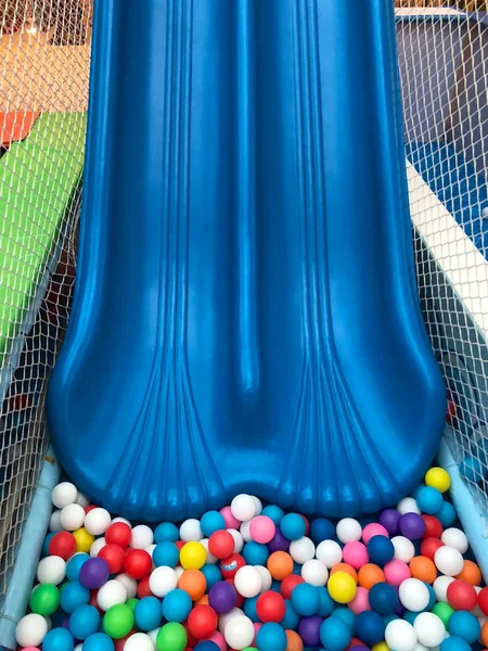 Modern children playground indoor. Inside the beautiful kids playground with a slide. Plastic dry pool with colorful balls for playing. Colorful plastic gum balls background in kid playroom