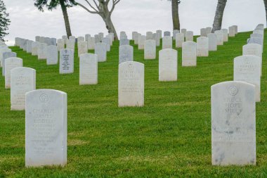 Fort Rosecrans National Cemetery with gravestones in rows during cloudy day. Federal military cemetery in the city of San Diego in Point Loma, California, USA. 03/07/2019 clipart